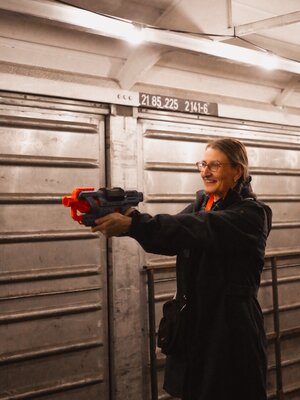 Guest holds a Nerf gun in her hand and aims at the cans.