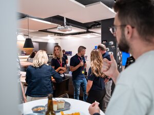 Teilnehmende stehen beim BeerTalk in kleinen Gruppen zusammen.