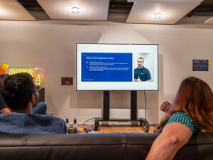 Das Publikum verfolgt eine Präsentation auf dem Bildschirm beim BeerTalk.