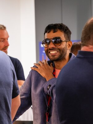Eine Gruppe von Männern unterhält sich am BeerTalk; ein Teilnehmer lächelt in die Runde.